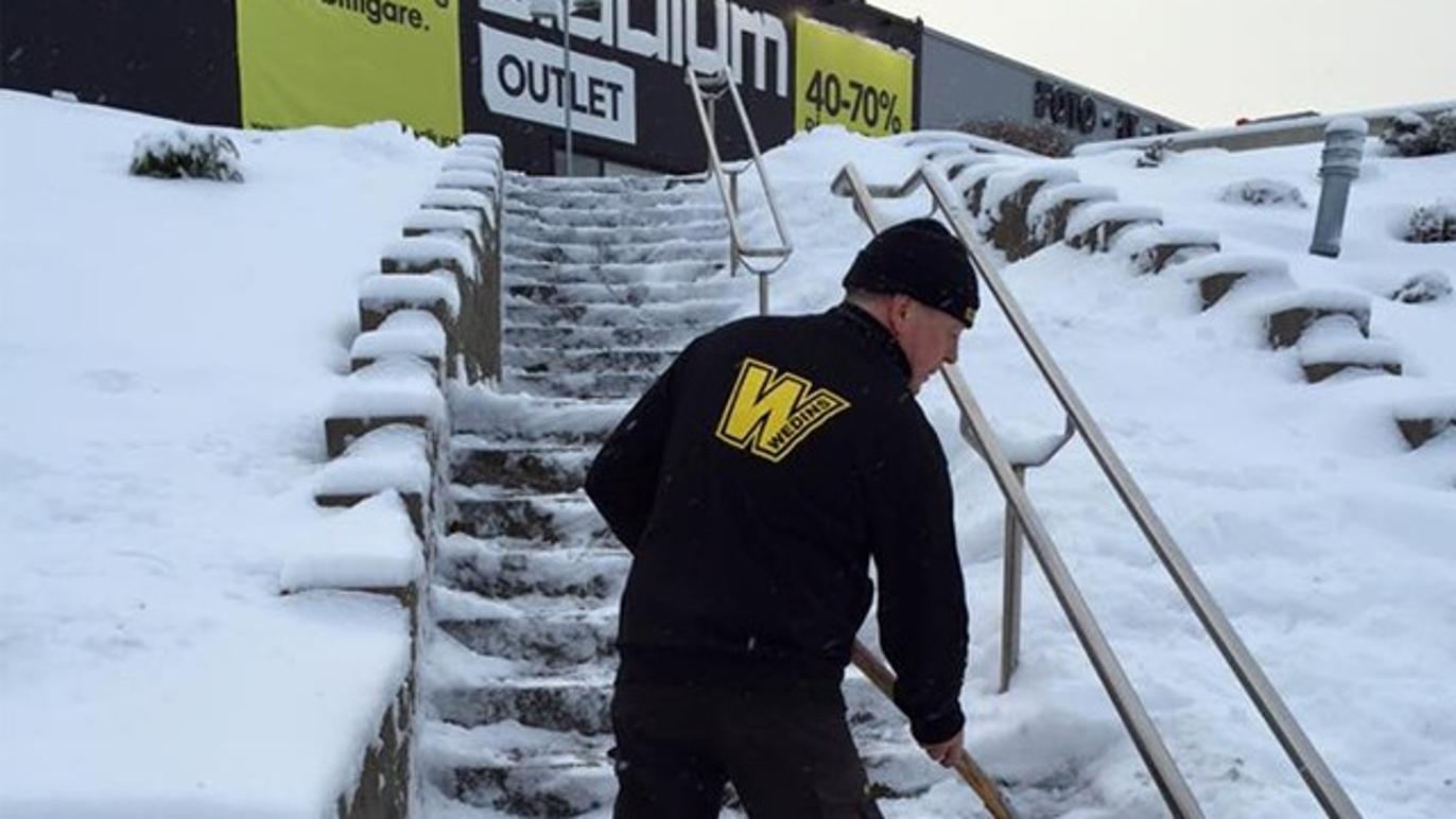 Snöskottning av trappa utanför butik i Sundsvall